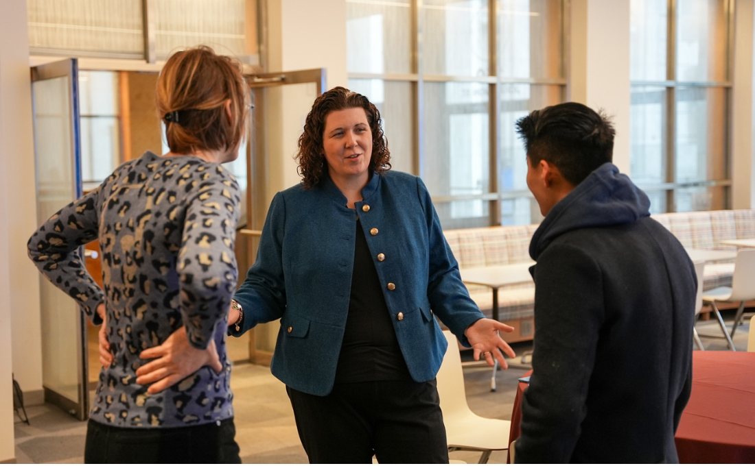 Sarah Jean Kelly, center facing camera, talks to two fellow Brooklyn Law School employees with their backs to the camera.